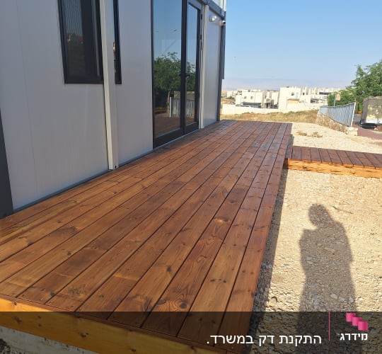 דק עץ חום ליד מבנה מודרני